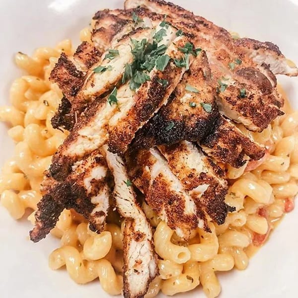 Cajun chicken pasta with cavatappi noodles, creamy sauce, and parsley from Cork & Crust Italian Kitchen.